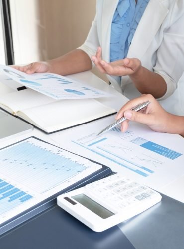 Two bussiness leader women discussing the charts and graphs showing the results.